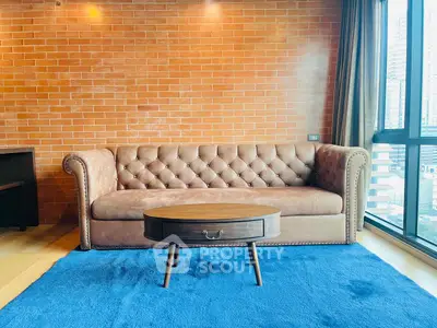 Stylish living room with elegant leather sofa and modern coffee table on vibrant blue rug.