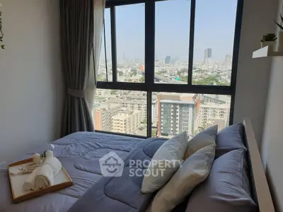 Stunning bedroom with panoramic city view from large window, featuring cozy bedding and elegant decor.