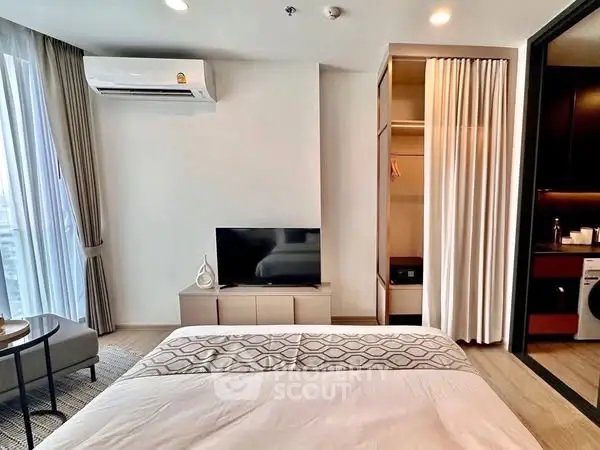 Modern bedroom with TV, air conditioning, and open closet in stylish apartment.