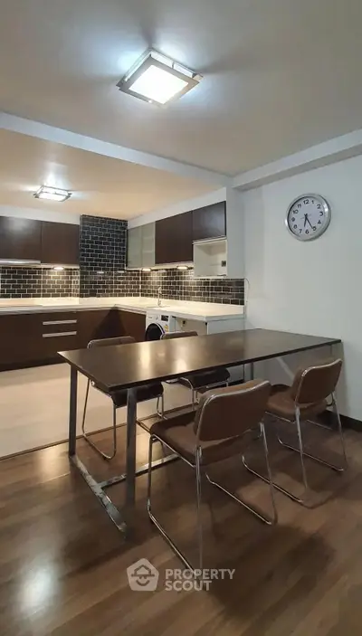 Modern kitchen with dining area, sleek cabinetry, and stylish lighting