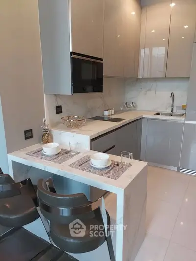 Modern kitchen with sleek cabinetry and marble countertops in a stylish apartment.