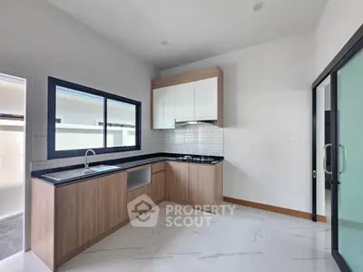 Modern kitchen with sleek design, featuring a gas stove and ample natural light.