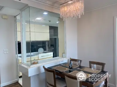 Elegant dining area with chandelier and mirrored wall in modern apartment