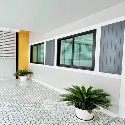 Modern balcony with stylish tile flooring and potted plants