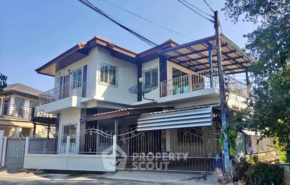 Spacious two-story house with modern design and gated entrance in a serene neighborhood.