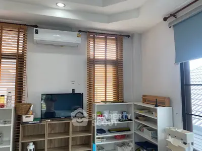 Bright and airy living room with modern shelving and air conditioning, perfect for comfortable living.
