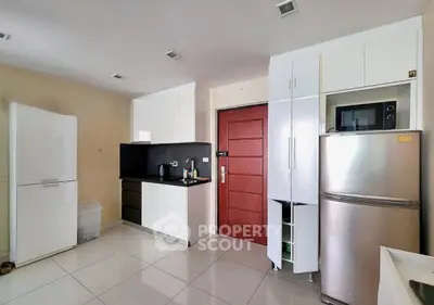 Modern kitchen with sleek white cabinets and stainless steel appliances in a stylish apartment.