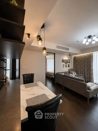 Modern living room with stylish decor and open layout, featuring elegant lighting and cozy seating area.