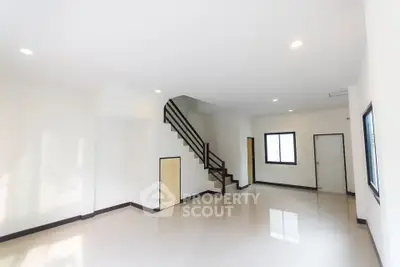 Spacious modern living room with staircase and glossy floors in a minimalist home