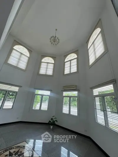 Spacious living room with high ceilings and large windows offering abundant natural light.