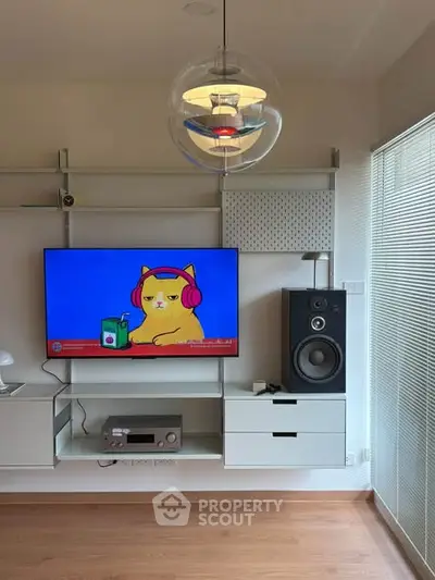 Modern living room with wall-mounted TV and stylish lighting fixture