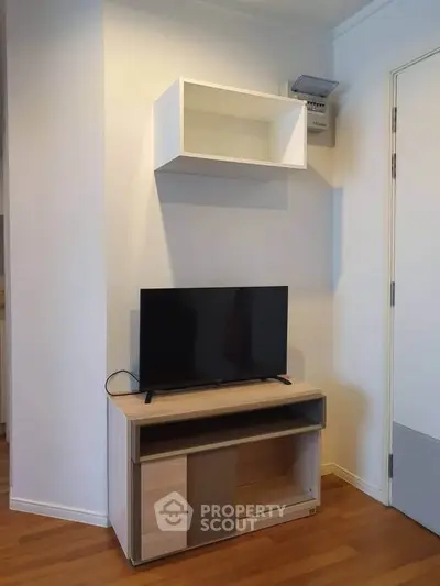 Modern living room with sleek TV stand and wall-mounted shelf, perfect for minimalist decor.