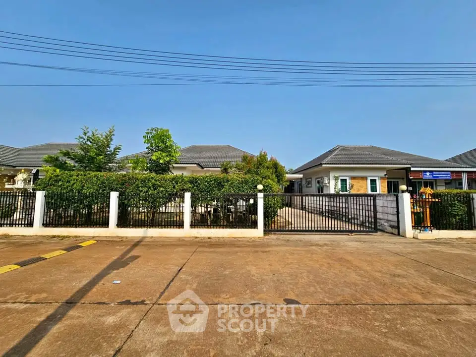 Charming suburban home with lush greenery and secure gated entrance.