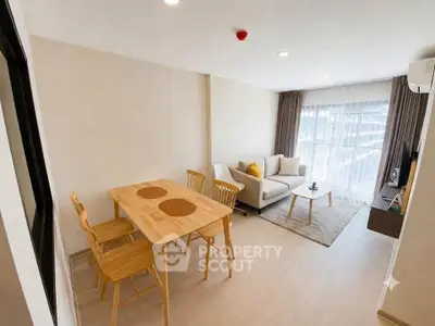 Modern living room with cozy seating and dining area, featuring large windows for natural light.