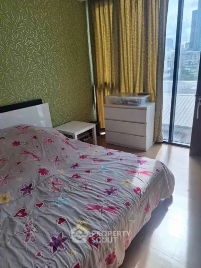 Charming bedroom with floral decor and city view from large window.