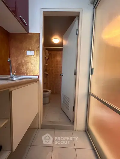 Compact kitchen with adjacent bathroom in a cozy apartment