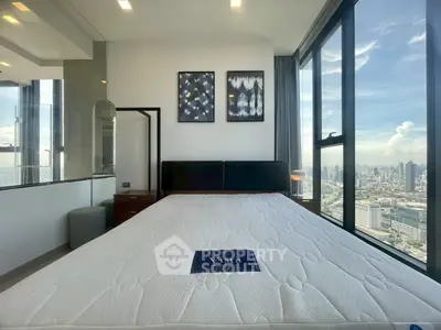 Luxurious bedroom with stunning city view and modern decor in high-rise apartment.
