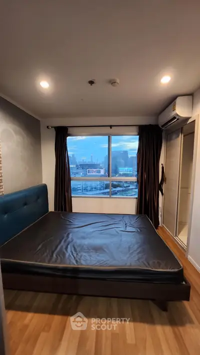 Modern bedroom with city view, featuring sleek design and ample natural light.