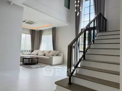 Luxurious modern living room with high ceilings and elegant staircase