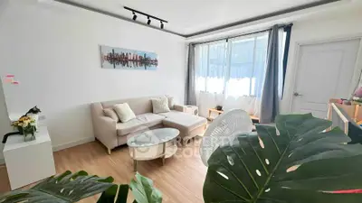 Modern living room with cozy sofa and large window, perfect for relaxation.