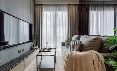 Modern living room with sleek decor and large windows offering natural light.