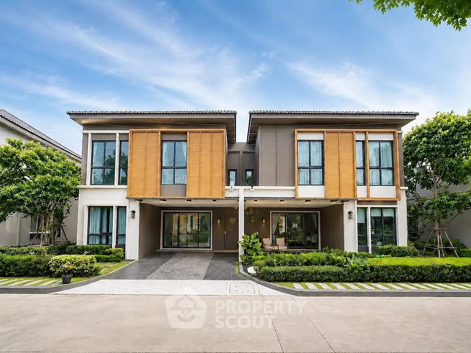 Stunning modern two-story house with lush landscaping and large windows