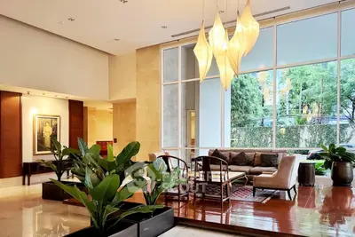 Luxurious living room with modern decor and large windows overlooking greenery.