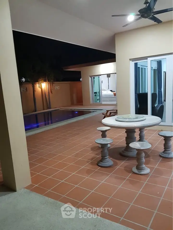 Luxurious poolside patio with elegant outdoor seating and night lighting