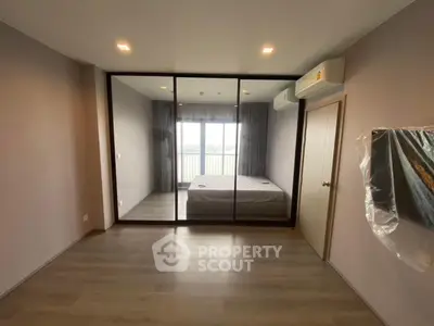 Modern bedroom with glass partition and air conditioning, featuring a minimalist design and wooden flooring.