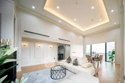 Luxurious living room with high ceilings and elegant decor, featuring a stunning view and spacious layout.