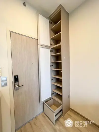 Modern apartment entrance with sleek storage solutions and wooden flooring