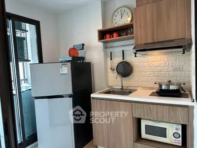 Modern kitchen with sleek appliances and stylish cabinetry in a cozy apartment setting.