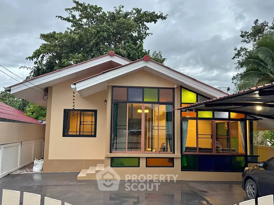 Charming single-story home with colorful windows and spacious driveway, perfect for family living.