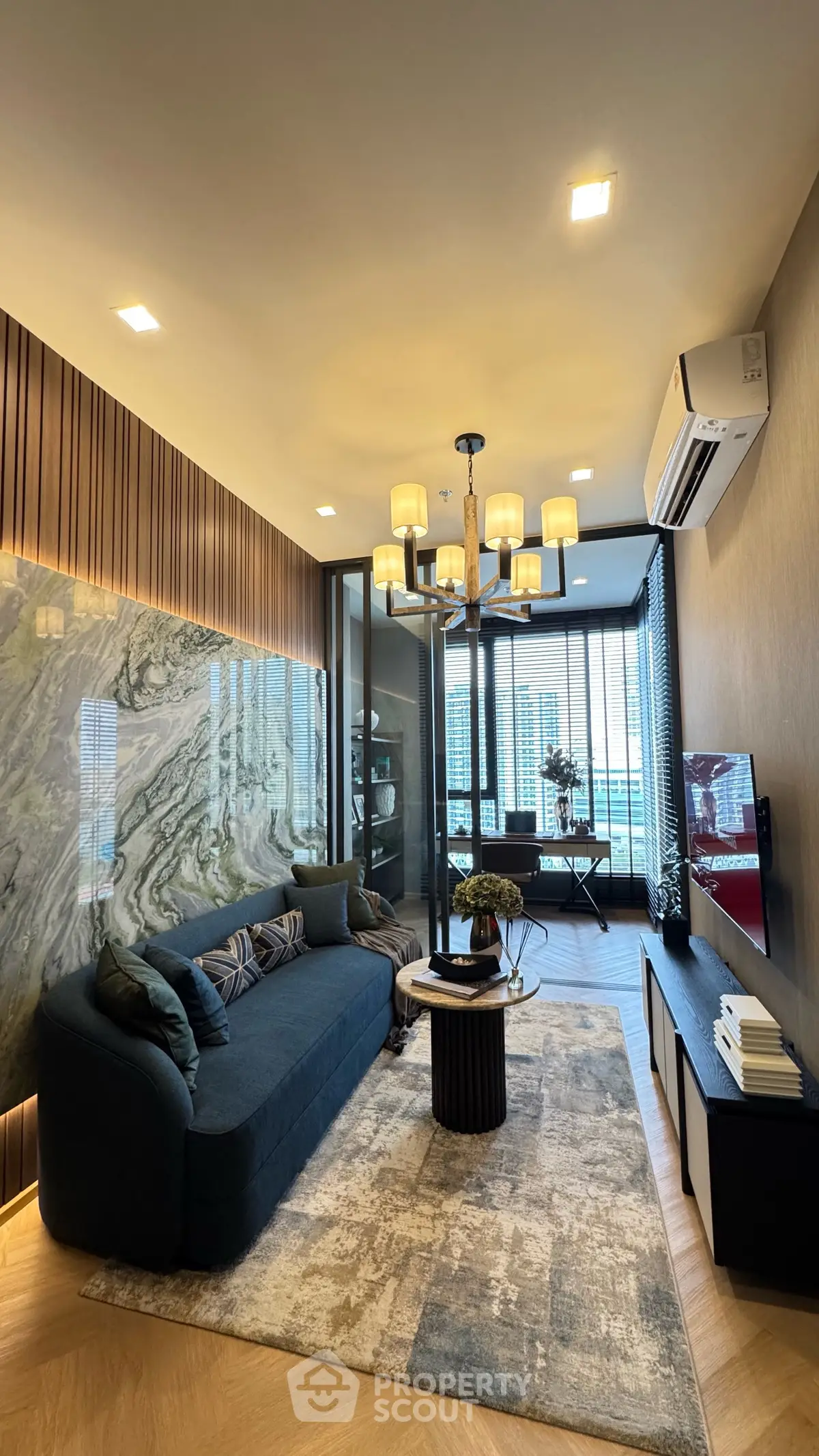 Luxurious modern living room with elegant decor and city view, featuring a stylish sofa and chandelier.