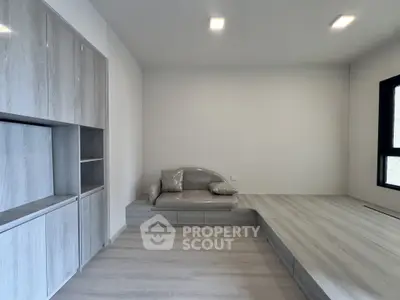 Modern minimalist living room with built-in storage and cozy seating area.