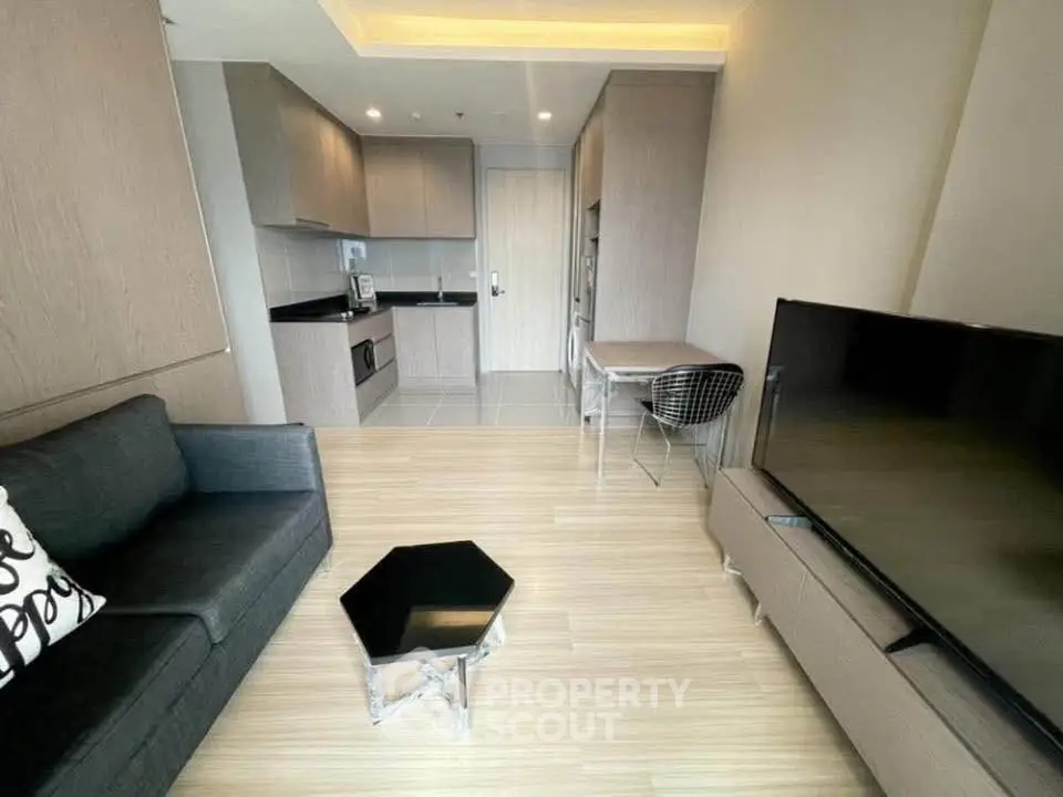 Modern living room with sleek furniture and open kitchen layout in a stylish apartment.