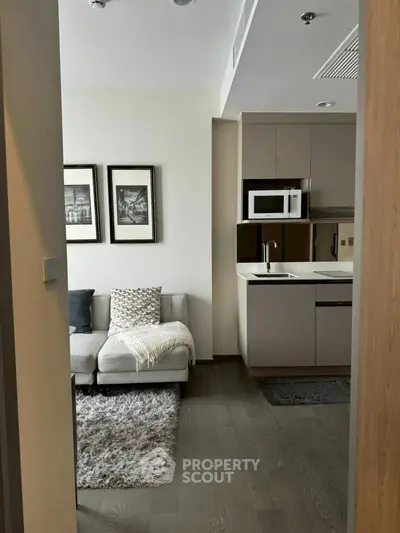 Modern open-plan living room and kitchen with cozy decor and sleek appliances.