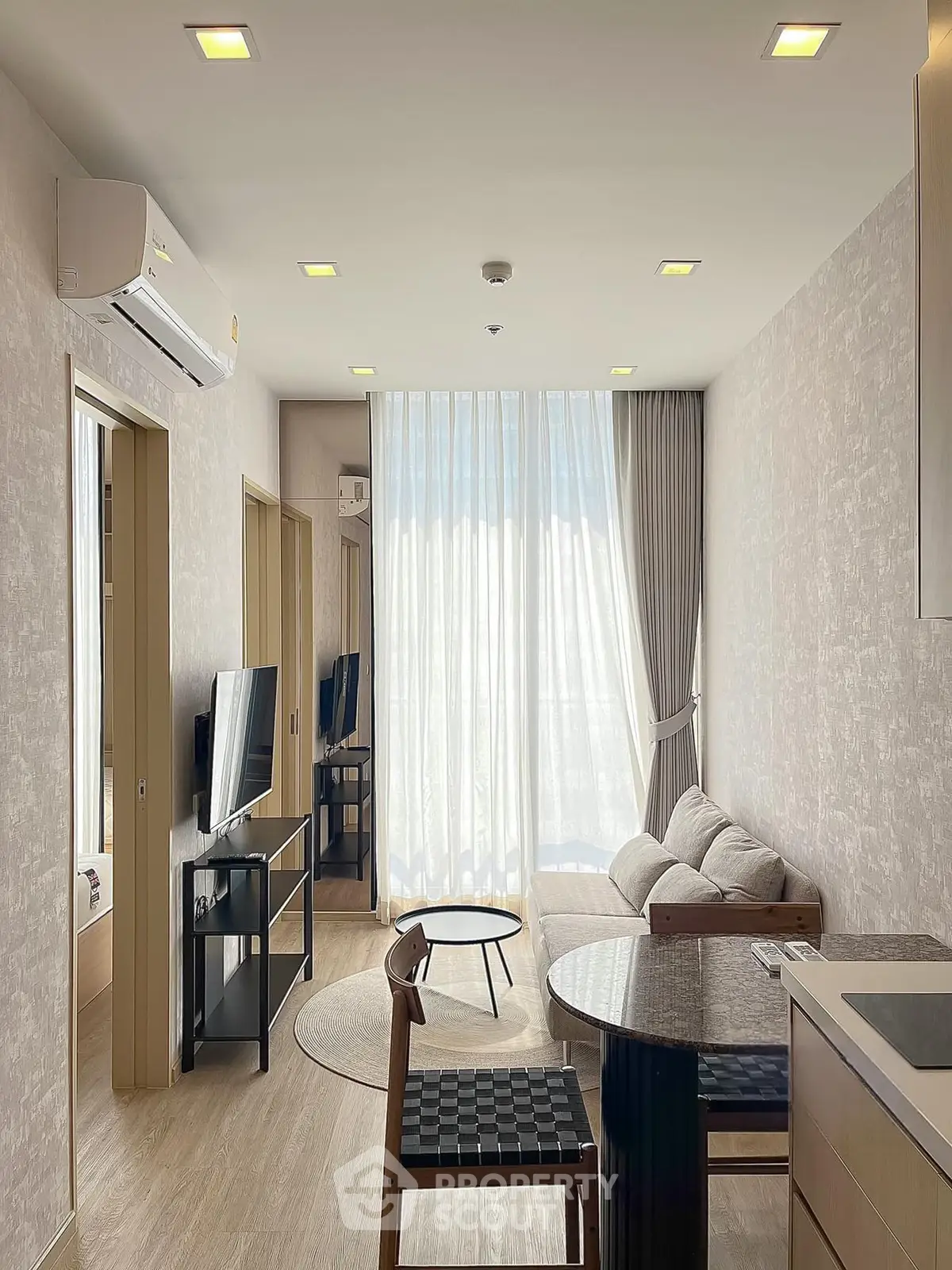 Modern living room with natural light, cozy sofa, and stylish decor in a contemporary apartment.