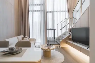 Modern living room with high ceilings and stylish staircase