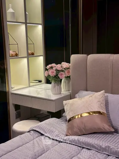 Elegant bedroom with plush bedding and stylish decor, featuring a cozy vanity area and soft lighting.