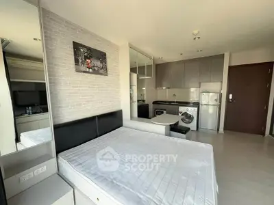 Modern studio apartment with sleek kitchen and cozy sleeping area, perfect for urban living.