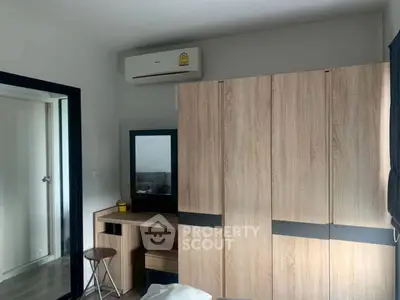Modern bedroom with sleek wardrobe and air conditioning unit, perfect for comfortable living.