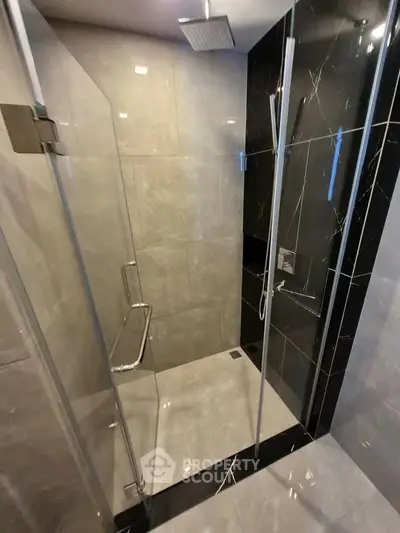 Modern bathroom with sleek glass shower enclosure and elegant tile design.