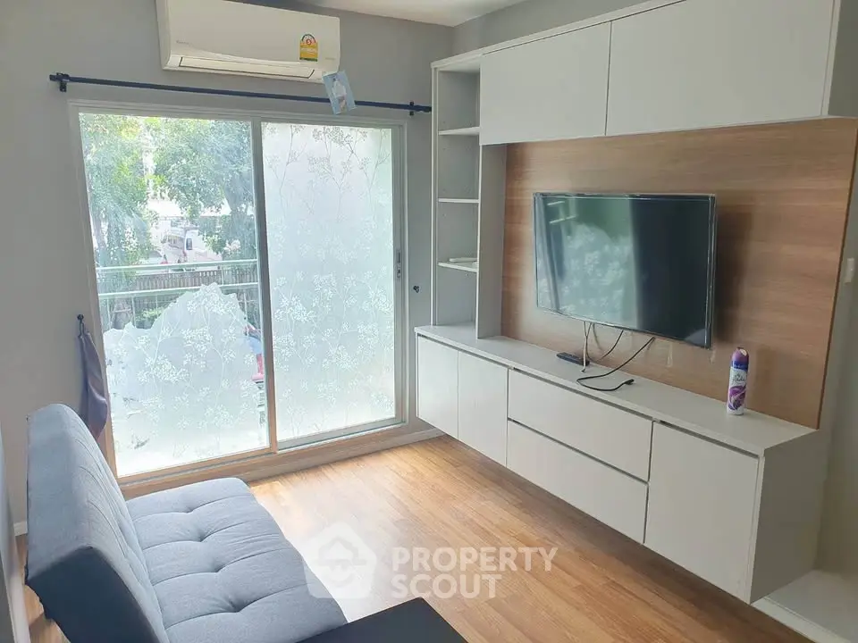 Modern living room with sleek built-in storage and large window for natural light.