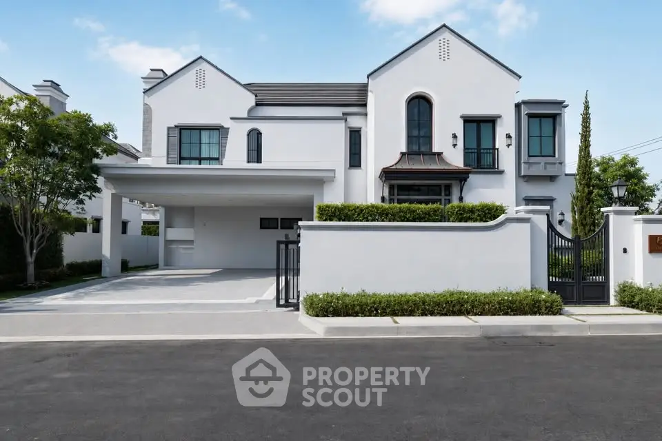 Elegant modern house with gated entrance and spacious driveway in a serene neighborhood.