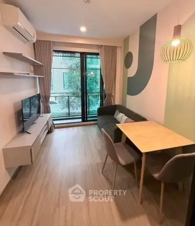 Modern living room with stylish decor, large window, and cozy dining area in a contemporary apartment.