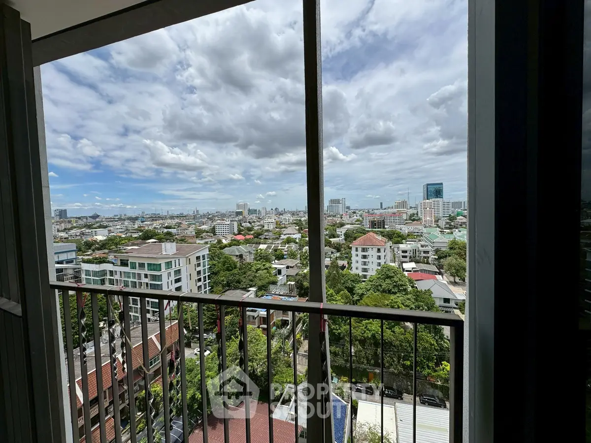 Stunning cityscape view from high-rise balcony with lush greenery and urban skyline.
