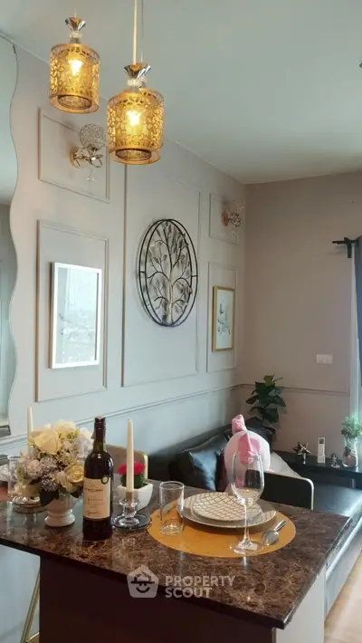 Chic living room with elegant decor and dining setup, featuring stylish lighting and wall art.