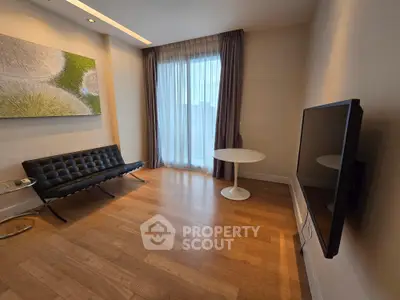 Modern living room with sleek furniture and large window, perfect for urban living.
