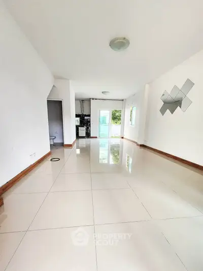 Spacious modern living room with glossy tile flooring and unique wall decor